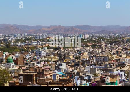 A view over rooftops in central Udaipur during the day. Hills can be seen in the distant. Stock Photo