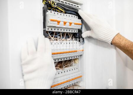 Electrician installing or repairing apartment electrical panel, close-up view Stock Photo