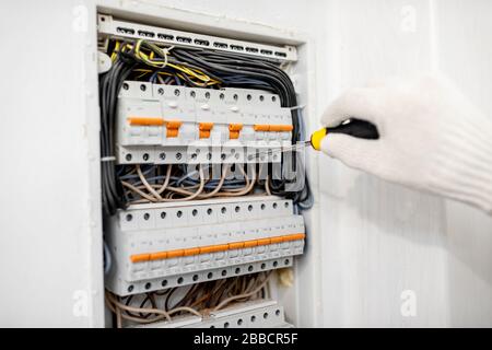 Electrician installing or repairing apartment electrical panel, close-up view Stock Photo