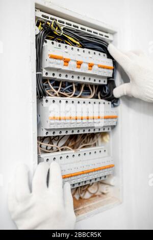 Electrician installing or repairing apartment electrical panel, close-up view Stock Photo