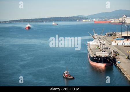 Bulk cargo freighter and tugboats in North Vancouver, British Columbia, Canada Stock Photo