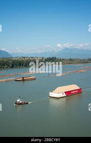 Tugboat and wood chip barge in the Fraser River near Surrey, British Columbia, Canada. Stock Photo