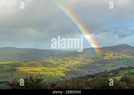 A rainbow almost over the Sugarloaf in the Brecon Beacons National Park in January in winter Stock Photo