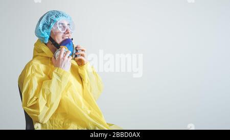 Happy medical worker puts off protective gear after a shift. Concept of covid-19 epidemic, healthcare personell and overworking in hospitals Stock Photo