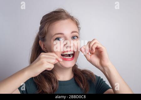 Funny smiling young caucasian woman girl using dental floss Stock Photo