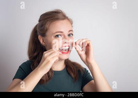 Funny smiling young caucasian woman girl using dental floss Stock Photo
