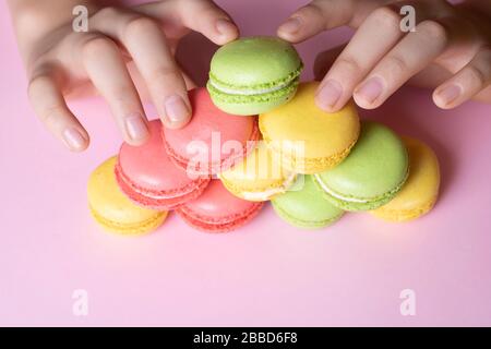 Boy holding colorful French macarons in hands, pyramid concept Stock Photo