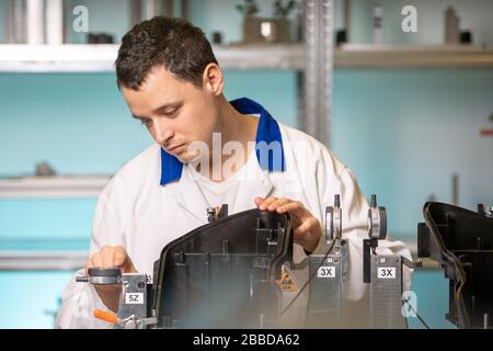 Automotive. Quality Engineer performs measurement of plastic casting for future light Stock Photo