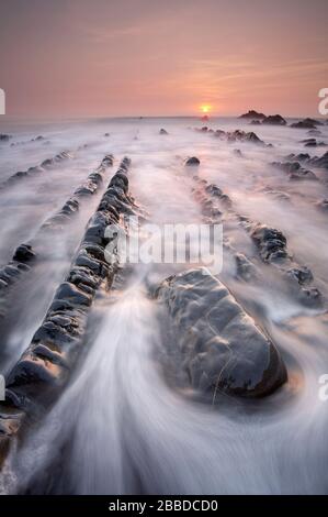 Sun setting at Welcombe Mouth Beach, Devon, England Stock Photo