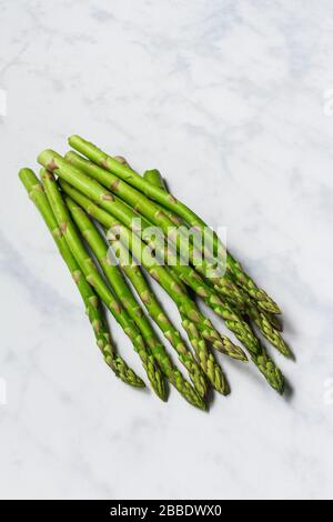 Bundle of fresh spring green asparagus on white marble Stock Photo