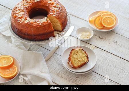 Sliced orange cake served on a white wooden table Stock Photo