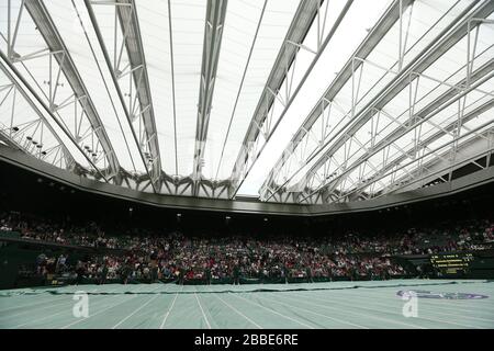 Groundstaff race to put the covers on centre court as rain stops play during the match between Poland's Agnieszka Radwanska and France's Mathilde Johansson during day four of the Wimbledon Championships at The All England Lawn Tennis and Croquet Club, Wimbledon. Stock Photo