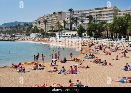 CANNES, FRANCE - MAY 14: Sunbathers at the public beach at the end of the Promenade de la Croisette on May 14, 1015 in Cannes, France. This promenade Stock Photo