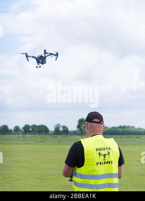 NIJVERDAL, NETHERLANDS - JUNE 23, 2018: Professional drone pilot controling a drone with camera Stock Photo