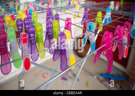 lots of colorful clothespins on a drying rack Stock Photo