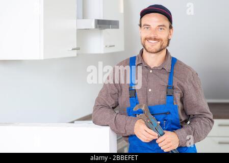 Installer with a pipe wrench at work Stock Photo