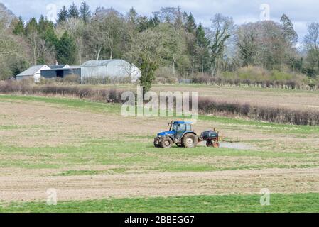 Perceton, Irvine, Scotland, UK - March 30, 2020: During Covid-19 lockdown Irvine Farmer carrying out essential spraying fields as agricultural work ha Stock Photo