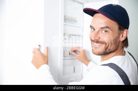 An electrician works on the house electrical system Stock Photo