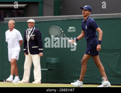 A ballboy is given a turn at a shot during USA's John McEnroe and Patrick McEnroe's game against Australia's Paul McNamee and Peter McNamara in their Gentlemen's Senior Invitation Double's match during day eight of Wimbledon held at The All England Lawn Tennis and Croquet Club Stock Photo