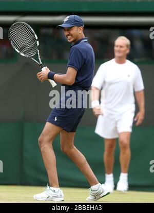 A ballboy is given a turn at a shot during USA's John McEnroe and Patrick McEnroe's game against Australia's Paul McNamee and Peter McNamara in their Gentlemen's Senior Invitation Double's match Stock Photo