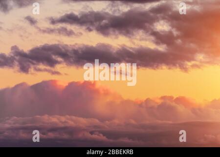 Evening sky with cumulus clouds in warm sunset colors Stock Photo
