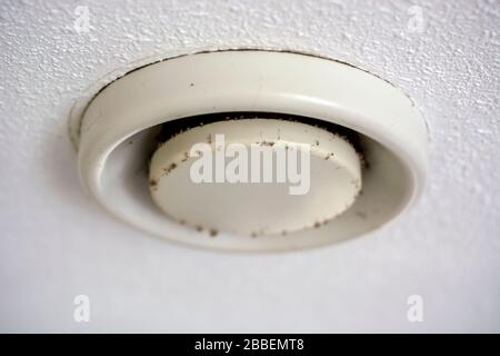Dirty old yellow used ceiling ventilation valve covered with dust and mold Stock Photo