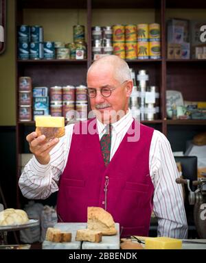 Vintage grocer isolated in wartime grocery shop, 1940s WWII summer event, Severn Valley Railway UK. WW2 rationing of food supplies: in this together. Stock Photo