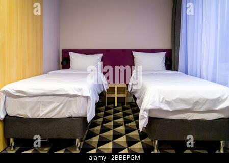 Hotel room with two double beds with pillows Stock Photo