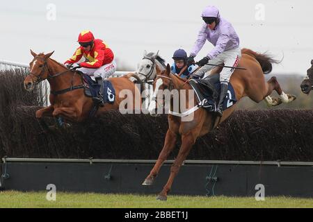 Race winner Tetlami ridden by Barry Geraghty (R) in jumping action ahead of Jackies Solitaire ridden by Noel Fehily in the Huntingdon Racecourse Novic Stock Photo