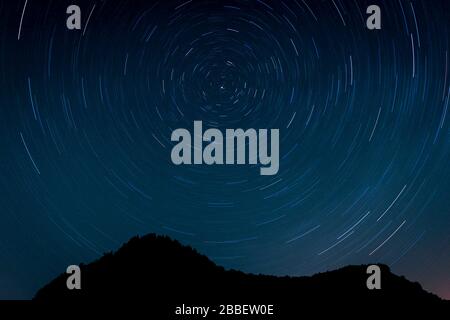 Starry sky with some mountains. Circumpolar star trail Stock Photo