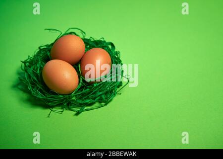 Easter eggs in a basket on green paper background Stock Photo