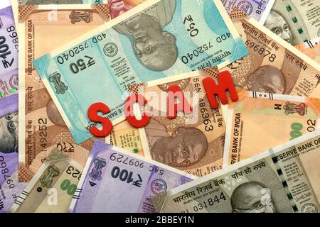 Scam and money concept,Scam red alphabet on money background,Indian Currency, Rupee, Indian Rupee,Indian Money, corruption concept Stock Photo