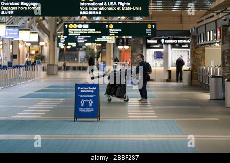 RICHMOND, BC, CANADA - MAR 29, 2020: Traveller in the international departures section of YVR which is nearly empty due to the COVID-19 coronavirus Stock Photo