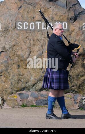 A welcoming piper at Carter Bar - Piper, Alan Smith,welcoming you over to Scotland from the England. Stock Photo