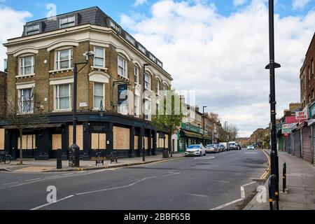 Stroud Green Road, Finsbury Park, North London UK, during the coronavirus crisis, with the boarded up World's End pub and closed shops Stock Photo