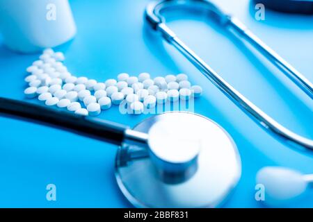 A capsules with reflection and stethoscope on blue background. Health care concept. Soft focus. Stock Photo