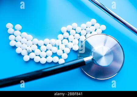 A capsules with reflection and stethoscope on blue background. Health care concept. Soft focus. Stock Photo