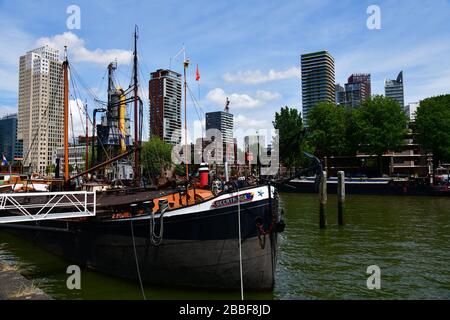 Rotterdam, The Netherlands; close up view of a number of historic river barges moored in the Oudehaven in Rotterdam with modern high rise Stock Photo