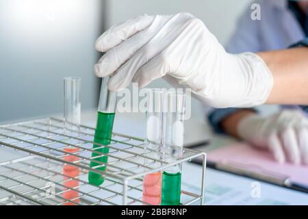 Scientist wear lab coat and protective wear are working with research or doing investigations with test tubes in experiment, Laboratory and developmen Stock Photo