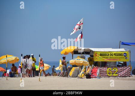 close up view of a stand selling drinks on Ipanema beach; filled with subathers and sun umbrellas Stock Photo