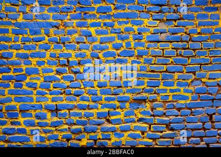 Brick wall painted in blue and yellow Stock Photo