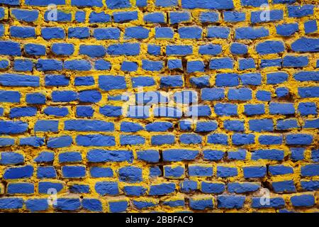 Brick wall painted in blue and yellow Stock Photo