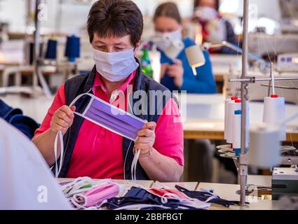 Wendisch Waren, Germany. 31st Mar, 2020. An employee of the Ber-Bek company is testing a straight sewn face mask to protect against corona viruses. The company normally produces chef's jackets and clothing for restaurant kitchens and switched production to protective masks a few days ago. Masks of different sizes and colours are sewn according to customer orders. Credit: Jens Büttner/dpa-Zentralbild/dpa/Alamy Live News Stock Photo