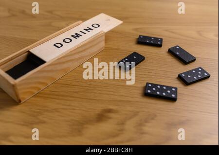 domino set black with tiles in wooden box on wooden background Stock Photo