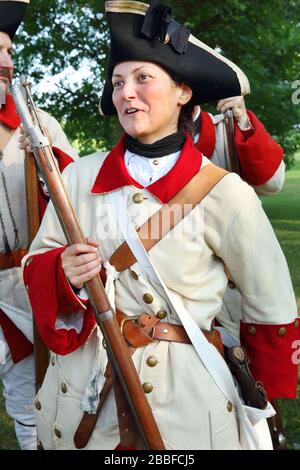 As part of the Fetes de la Nouvelle-France (New France Festival), a young woman prepares to take part in a parade wearing the uniform of the French Army's Regiment de Bearn which was originally sent in 1755 to defend Fort Frontenac in Quebec City, Province of Quebec, Canada Stock Photo