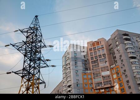 High-voltage networks, residential buildings against the evening sky Stock Photo