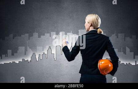 Businesswoman draws silhouette of business center Stock Photo