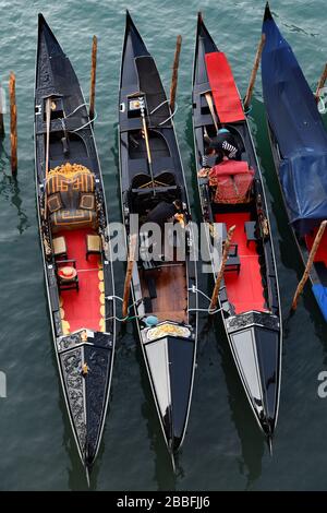 Venice, Italy-February 2020; High angle, close up view of a number of traditional Venetian gondolas being wiped dry by gondoliers Stock Photo