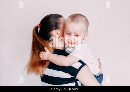 Crying toddler girl being consoled by her mother Stock Photo