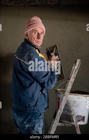 Construction worker plastering interior wall using cement plaster  Worker plastering the wall by concrete at the construction site Stock Photo